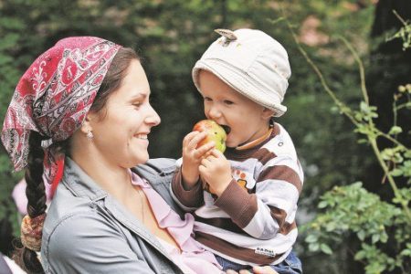 Das Kind isst einen Apfel, der nicht von Krankheiten und Schädlingen befallen ist